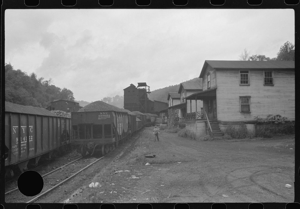 [Untitled photo, possibly related to: Coal miner's child taking home kerosene for lamps. Company houses, coal tipple in…