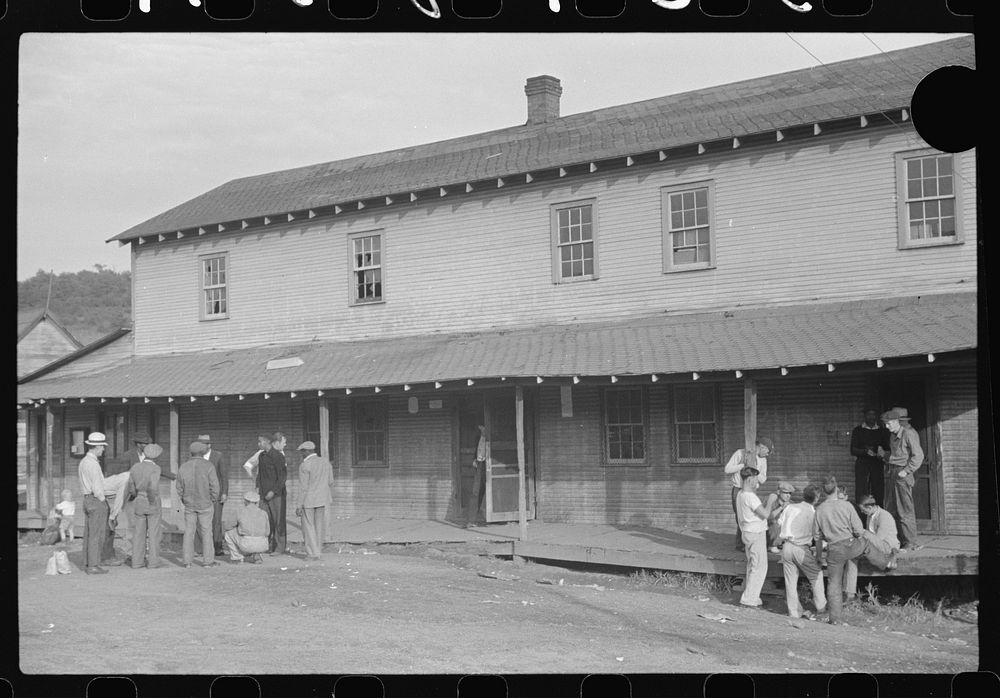 [Untitled photo, possibly related to: Company store, Saturday afternoon. At left, miners shooting craps; at right, card…