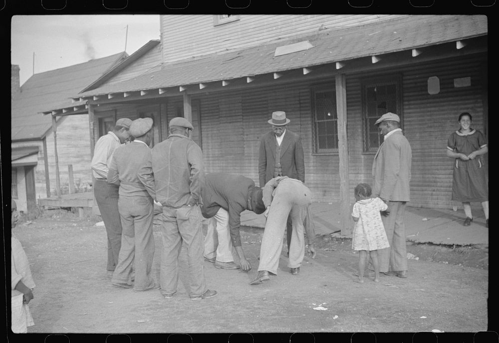 Coal miners shooting craps in front of company store, Chaplin, West Virginia. Sourced from the Library of Congress.