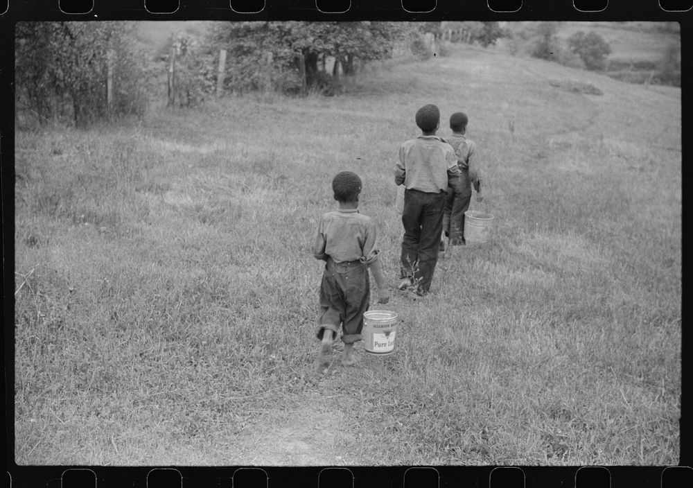 Three of miner's children going down hill to get water in old lard cans. Chaplin, West Virginia by Marion Post Wolcott