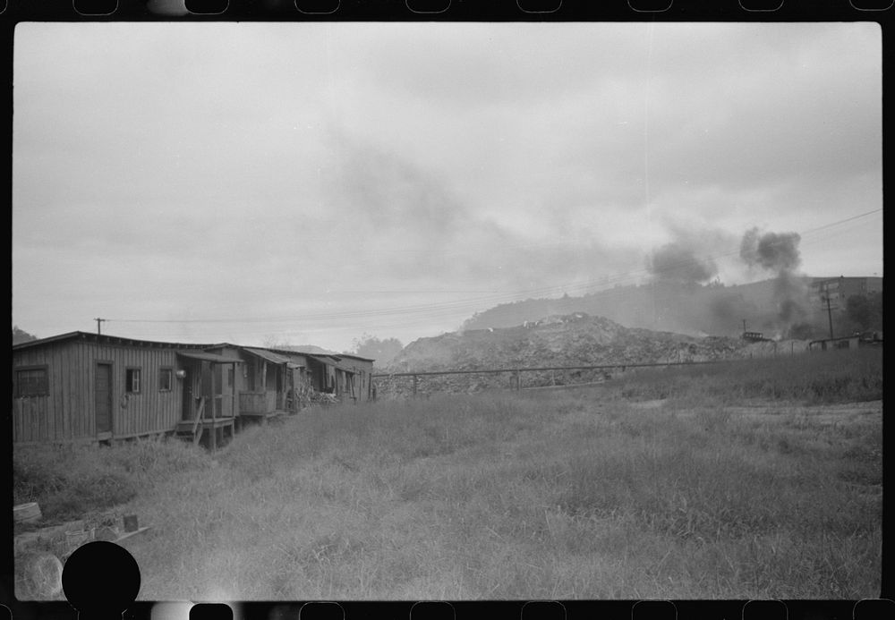 [Untitled photo, possibly related to: Section of Rosedale Mining Company. Shanties by the river (burning slag pile to…