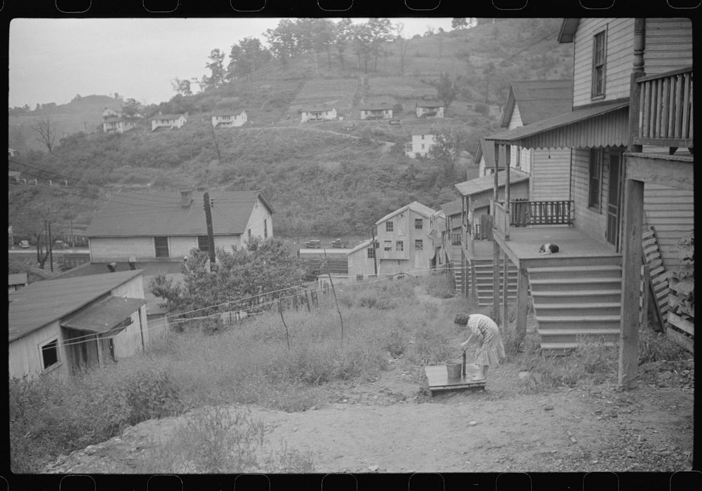 Coal miner's wife getting water from pump, company houses, Pursglove, Scotts Run, West Virginia. Sourced from the Library of…