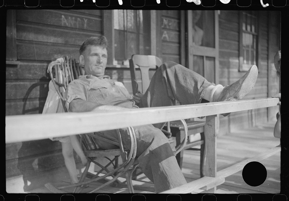 [Untitled photo, possibly related to: Former coal miner sitting on his front porch. He is the town philosopher. He repairs…
