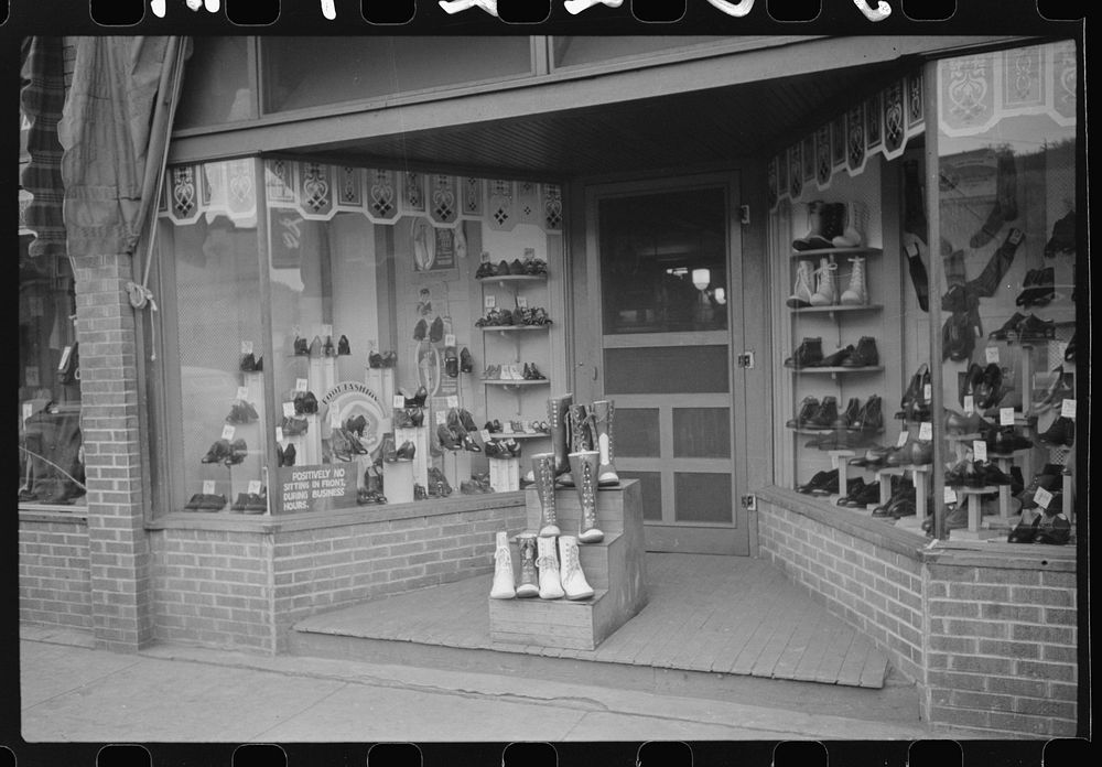 Shoe store with miners safety boots on display in foreground, Scotts Run, West Virginia. Sourced from the Library of…