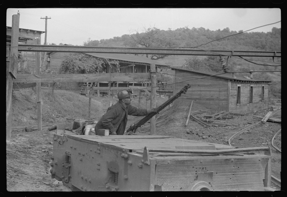 Coal miners switching motor. Note live wires. The "Patch," Chaplin, West Virginia. Sourced from the Library of Congress.