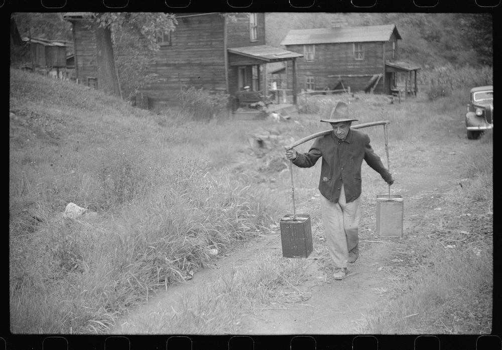 Mexican miner carrying water up the hill to his home, about two miles. Bertha Hill, West Virginia. Sourced from the Library…