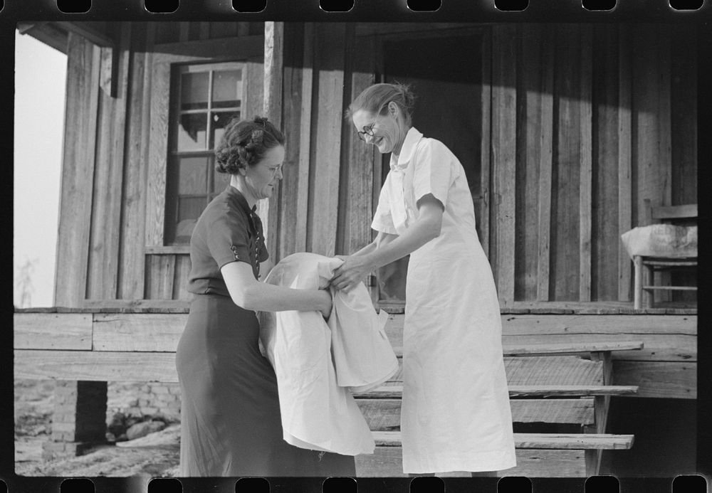 Miss Hesterley, FSA (Farm Security Administration) supervisor, delivers sheeting to Mrs. A.L. Lanier on undeveloped…