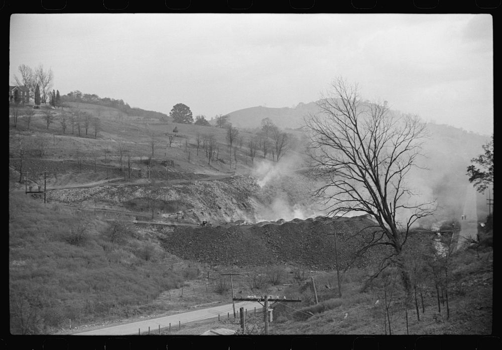 [Untitled photo, possibly related to: General view from top of coal mine tressle, showing burning slag heaps and holes of…