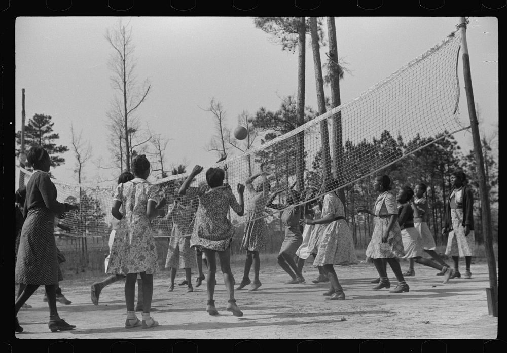 Students playing volleyball during supervised outdoor recreational period at new FSA (Farm Security Administration) project…