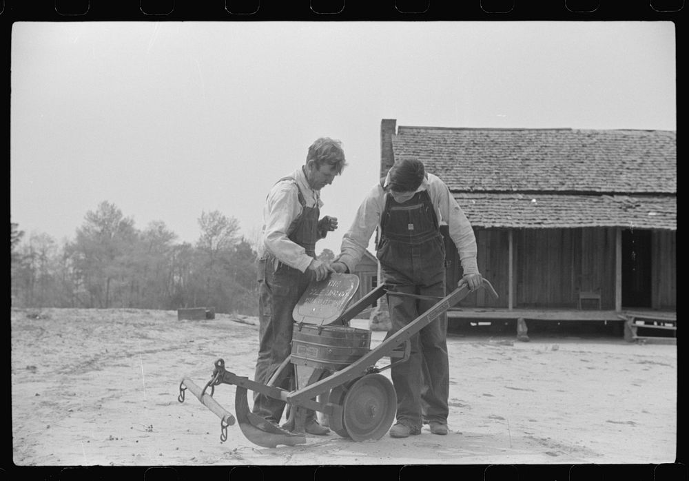 Mr. Ellis Adkins and his son, rural rehabilitation borrowers, examining new cultivator bought with FSA (Farm Security…