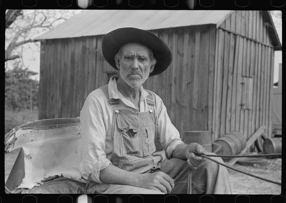 Lee Betties, rural rehabilitation client, with sack of horse and mule feed on rear of his wagon, leaving general store at…