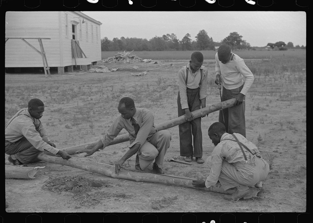 Group of sixth and seventh grade boys constructing poultry yard fence. Brooder was built in their shop class at school.…