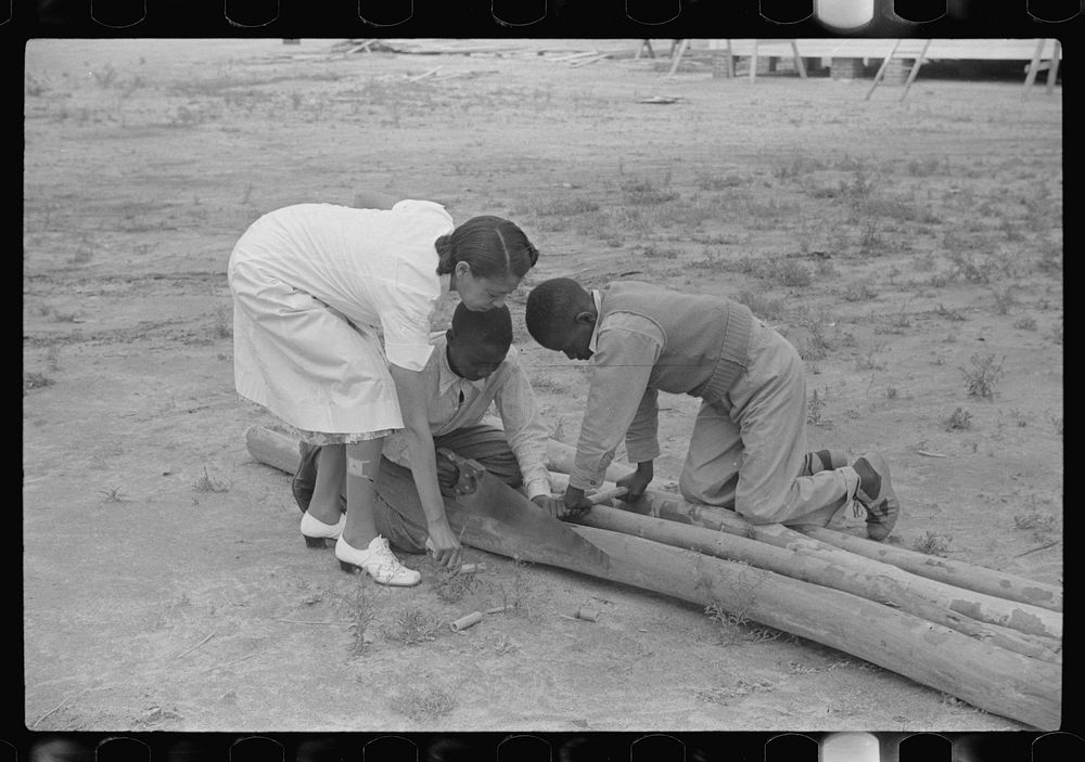 [Untitled photo, possibly related to: Students sawing pieces of bamboo for home economics class to be used in making looms…