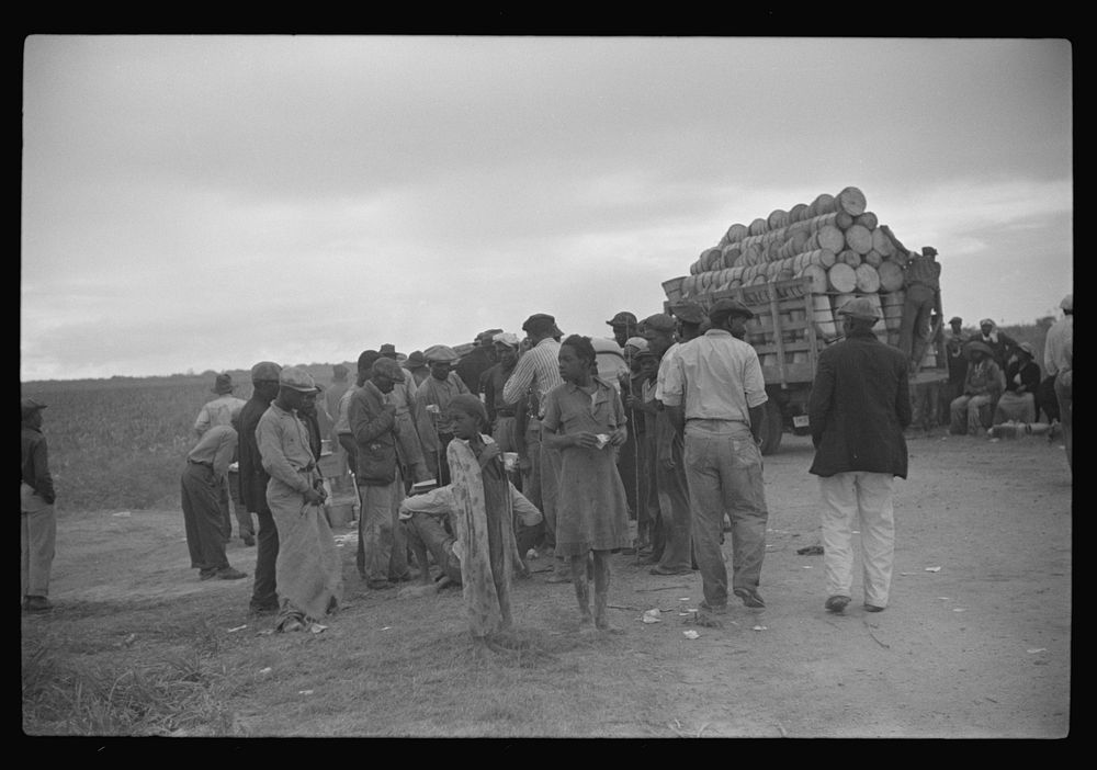 Vegetable pickers, migrants, waiting after work to be paid. Near Homestead, Florida. Sourced from the Library of Congress.