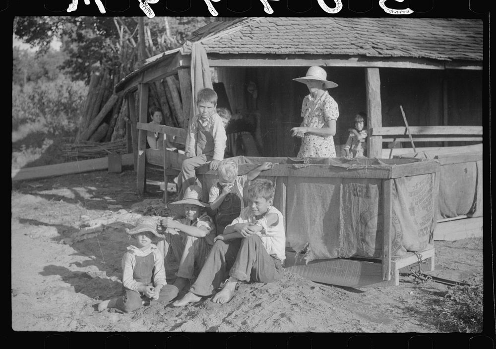Children of sharecropper sitting near tobacco shed, outside house, near Manning, South Carolina. Sourced from the Library of…
