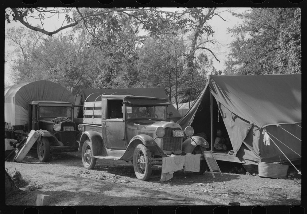 [Untitled photo, possibly related to: Fixing truck in front of tents of Mexican labor brought from Texas by contractor for…