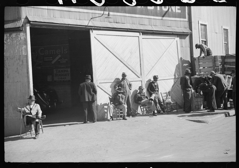 [Untitled photo, possibly related to: Farmers waiting and buying apples outside warehouse during tobacco auctions. Durham…