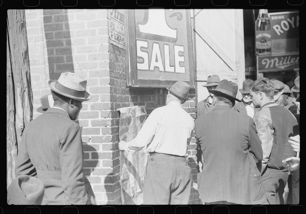 Patent medicine salesman demonstrating his wares to farmers outside warehouse during tobacco auction sales. Durham, North…
