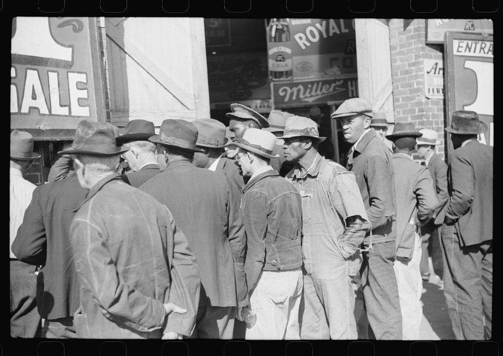 [Untitled photo, possibly related to: Spectators listening to patent medicine salesman who has his stand outside tobacco…