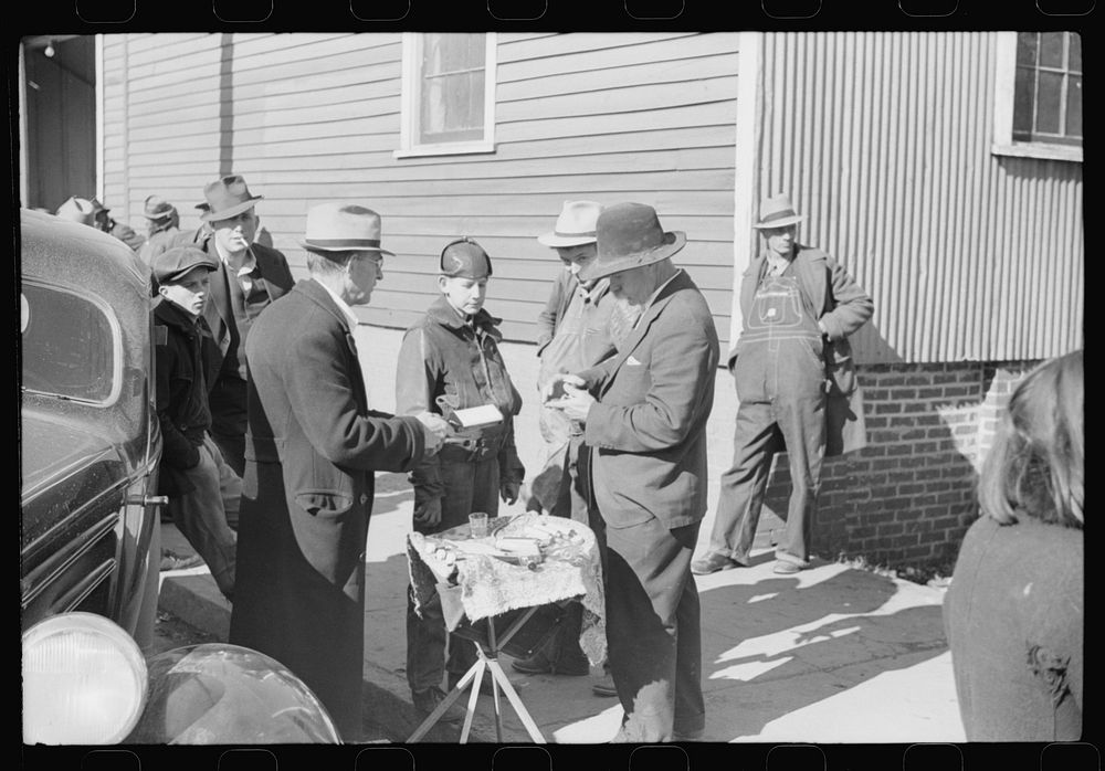 [Untitled photo, possibly related to: Salesman displaying patent medicine to farmers who have brought tobacco to warehouse…