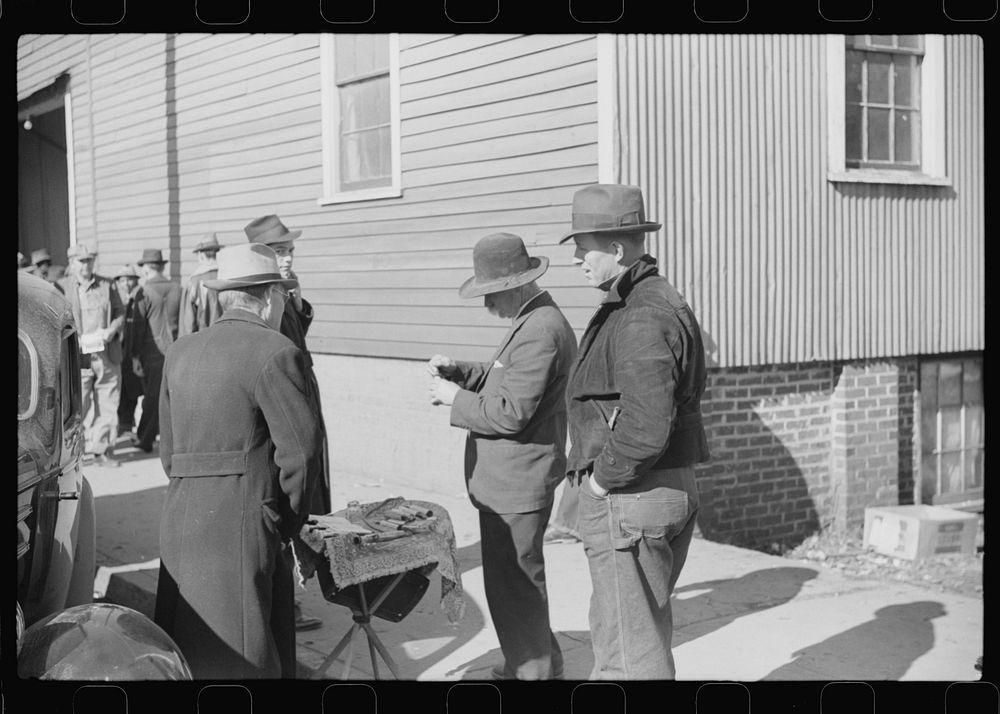 [Untitled photo, possibly related to: Salesman displaying patent medicine to farmers who have brought tobacco to warehouse…
