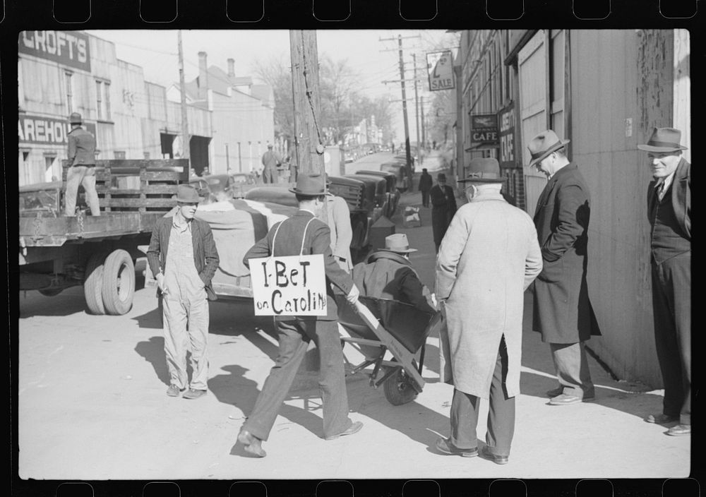 Tobacco auctioneer who "bet on Carolina" and lost, pays off the wager by pushing the warehouseman in a wheelbarrow from the…