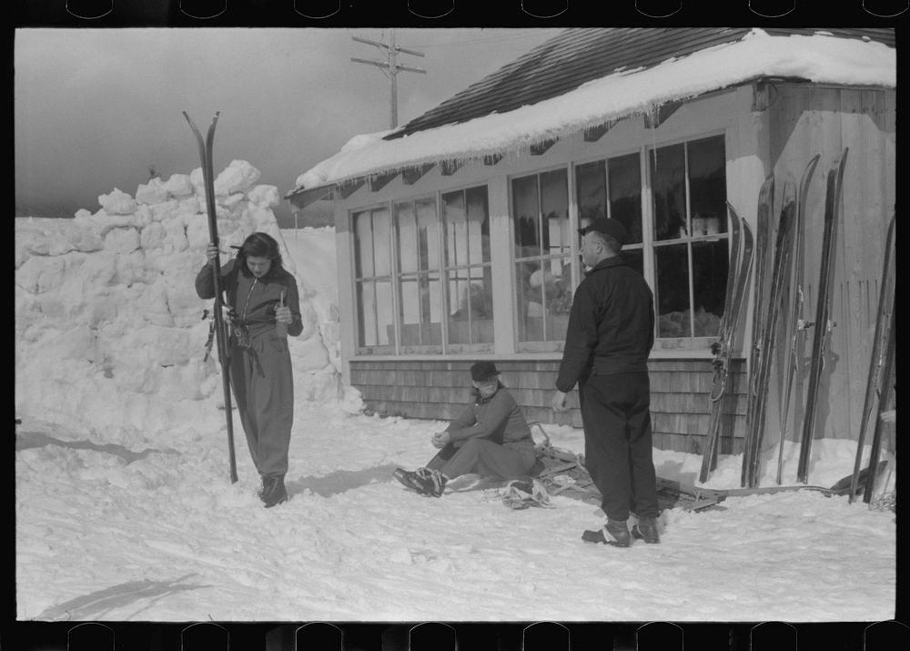 Skiers during noon hour outside of toll house at foot of Mount Mansfield, Smugglers Notch. Near Stowe, Vermont. Sourced from…