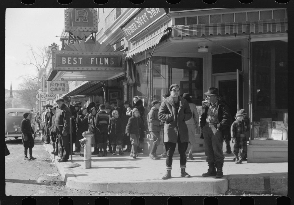 Children and farmers waiting to go into movie on Saturday afternoon. Littleton, New Hampshire. Sourced from the Library of…