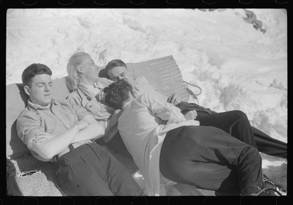 Skiers relaxing in the sun during noon hour outside of forest ranger's hut near the top of Mount Mansfield, Smuggler's…