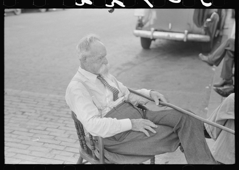 "Kentucky colonel" sitting in street in front of courthouse. Versailles, Kentucky. Sourced from the Library of Congress.