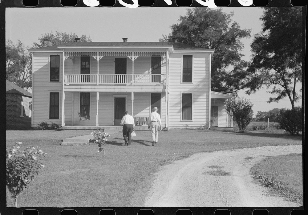 Priest going into rectory on church grounds during St. Thomas church picnic. Near Bardstown, Kentucky. Sourced from the…