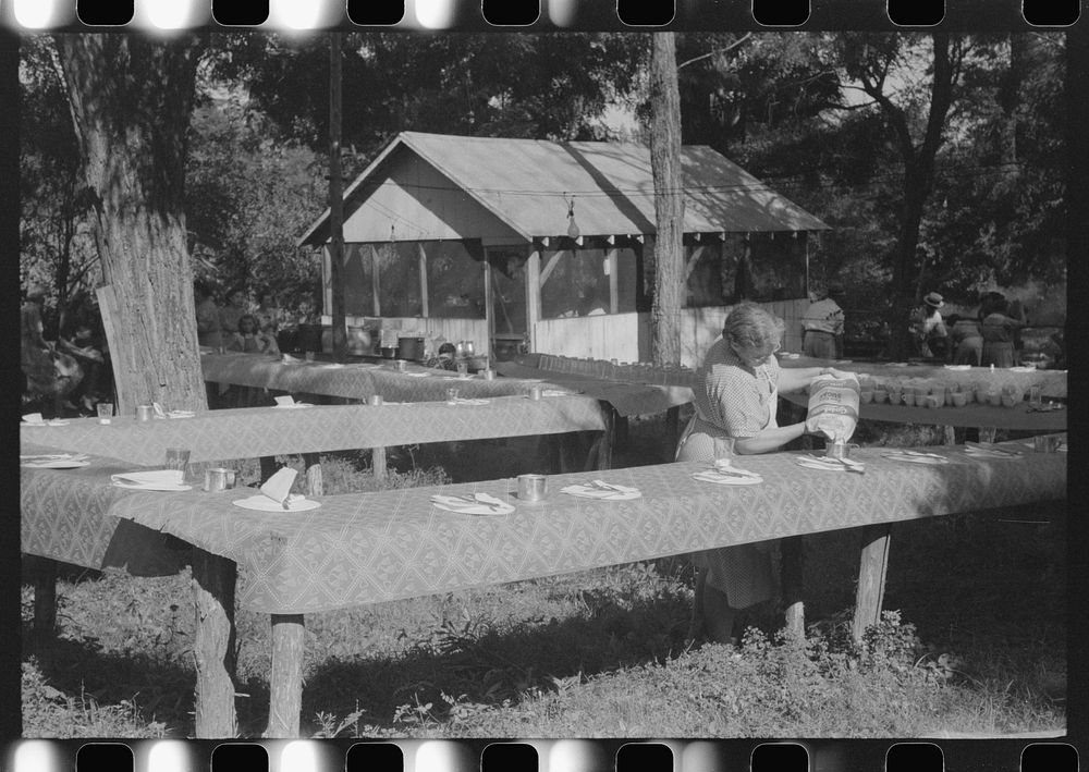 One of the food committee members fixing the table for the St. Thomas Church picnic supper, near Bardstown, Kentucky.…