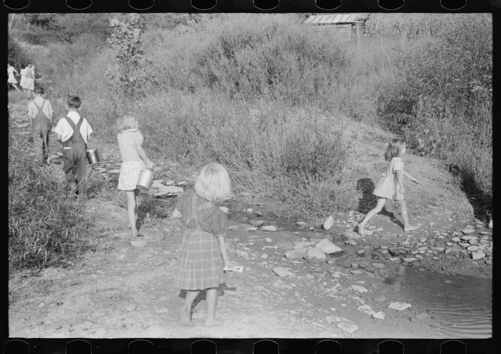 Children going home from school up Frozen Creek carrying their lunch pails. School is held in the summer and stops in…