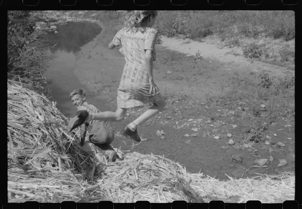 [Untitled photo, possibly related to: Pouring off and straining finished sorghum syrup after it had been boiled down at a…