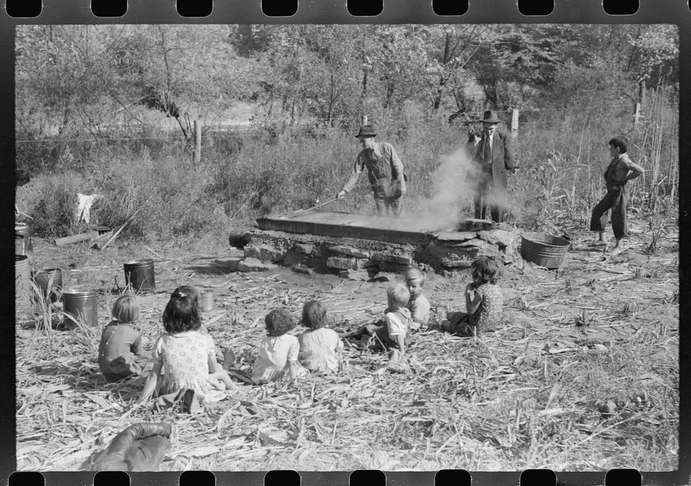 [Untitled photo, possibly related to: Homebuilt boiler pit made of mud and rocks where the sap from the sorghum cane is…