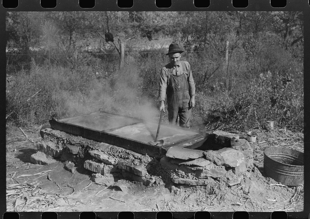 Homebuilt boiler pit made of mud and rocks where the sap from the sorghum cane is boiled down to the syrup.The man who does…