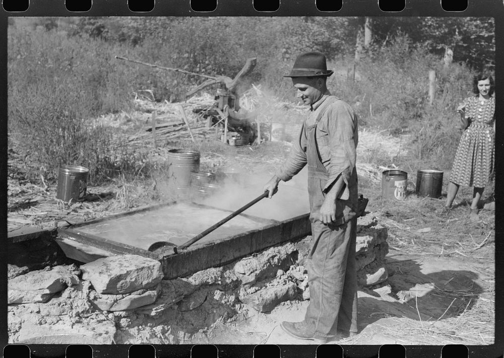 [Untitled photo, possibly related to: Homebuilt boiler pit made of mud and rocks where the sap from the sorghum cane is…