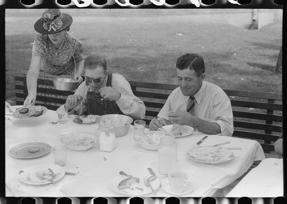 Eating dinner served for benefit of the church in courthouse yard on court day. Campton, Wolfe County, Kentucky. Sourced…