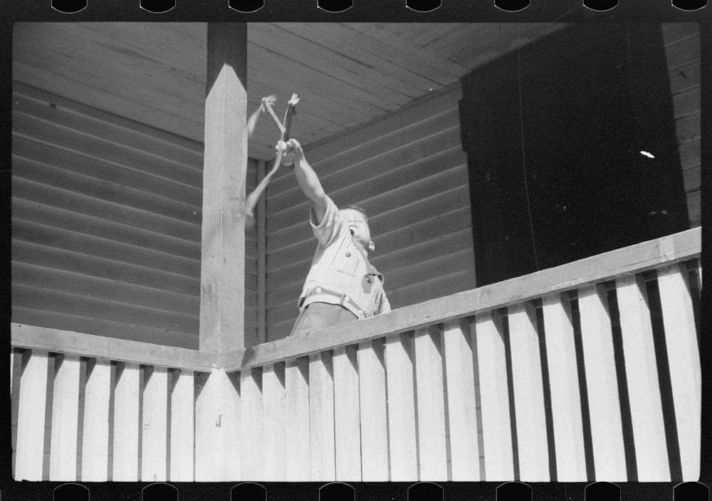 [Untitled photo, possibly related to: Mountain child shooting slingshot from porch of his home. Near Buckhorn, Kentucky].…