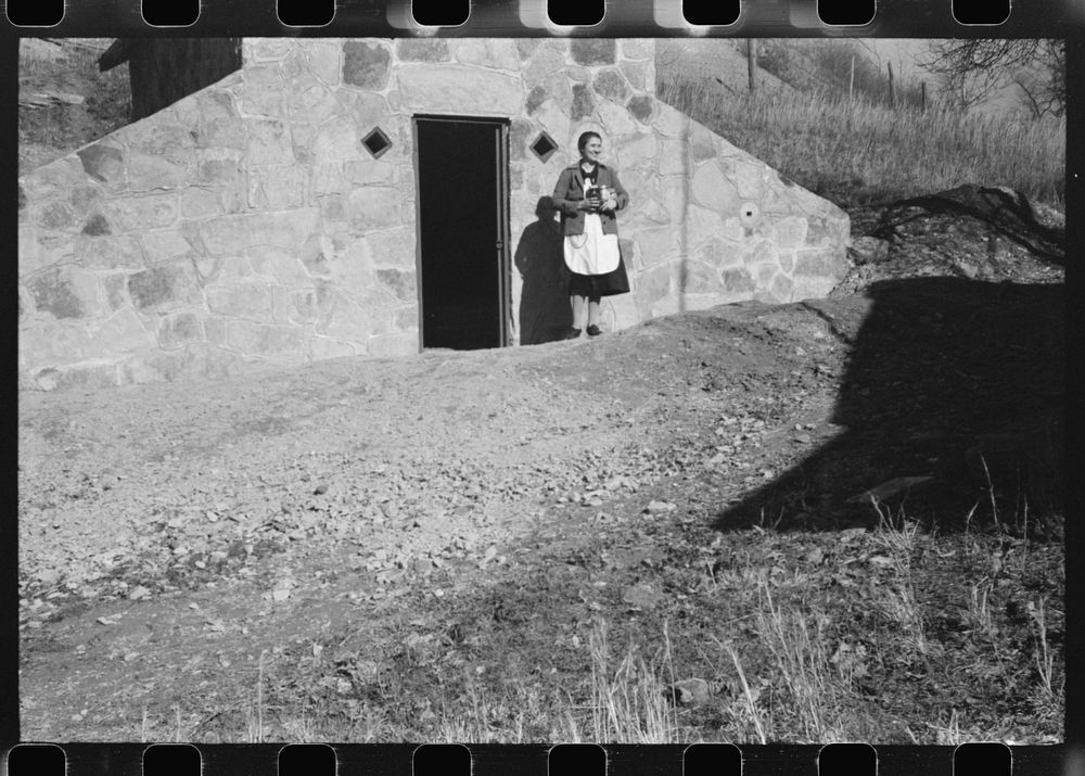 [Untitled photo, possibly related to: Mrs. S. Castle or Mrs. William S. Allen with canned goods in front of new storage…