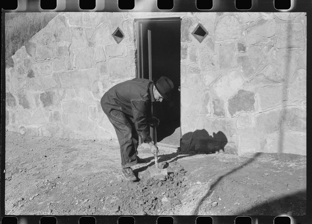 Mr. S. Castle or Mr. William S. Allen working in front of new storage house he built on their farm with FSA (Farm Security…