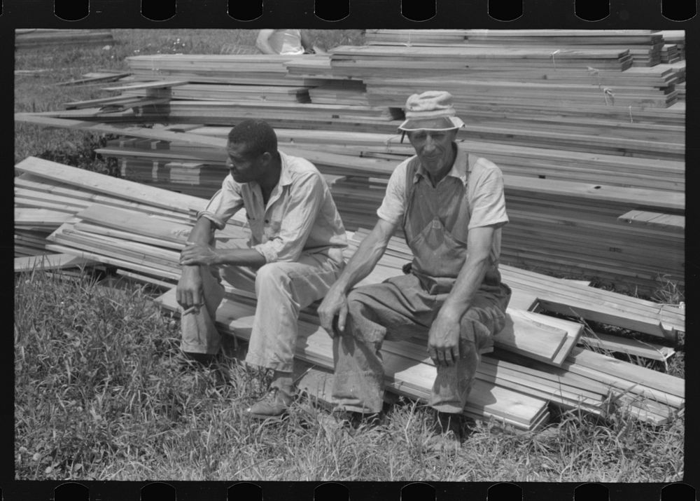 [Untitled photo, possibly related to: Workers during lunch hour putting up prefabricated defense houses managed by FSA (Farm…