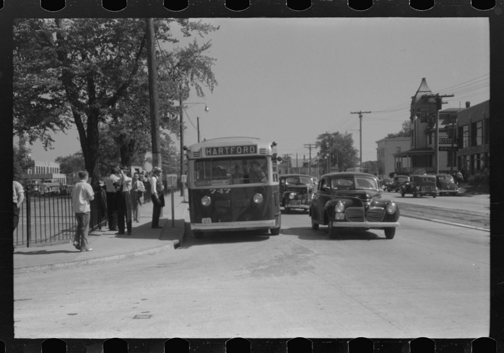 Buses which take many workers home in front of United Aircraft, Pratt and Whitney plant, East Hartford Connecticut. Sourced…