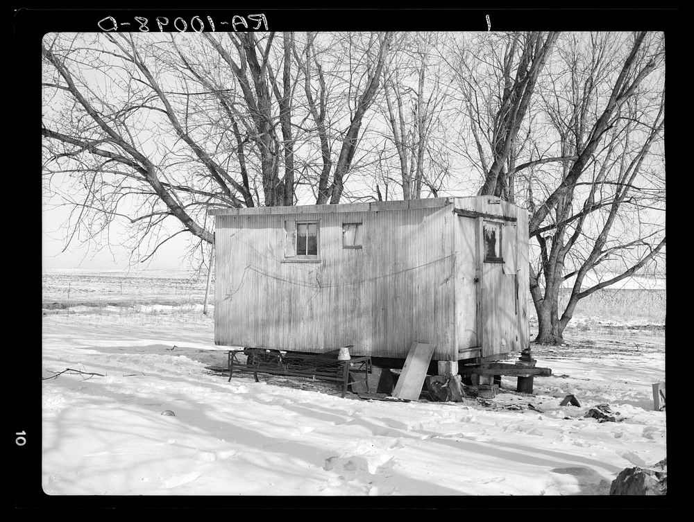 Trailer house owned by Clifford Blum. They lived in this for one year while he was farming eighty acres without buildings by…
