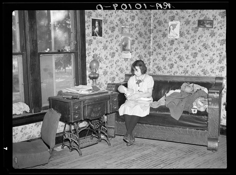 One of Edgar Allen's children playing with doll. The couch and sewing machine are the two most substantial pieces of…
