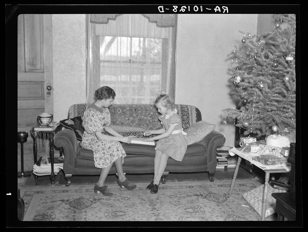Children of H.H. Tripp wrapping presents for Christmas. Near Dickens, Iowa. Tripp operates his mother's farm by Russell Lee