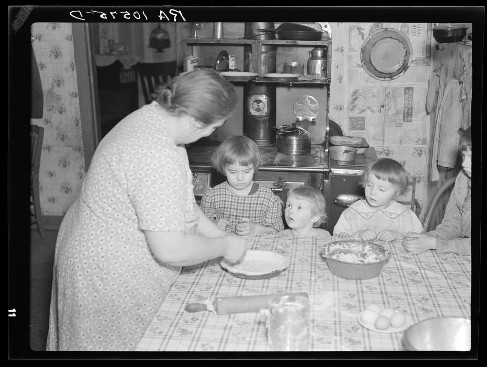 7:45 a.m. Tip Estes' children watch their mother make a pie. Near Fowler, Indiana by Russell Lee