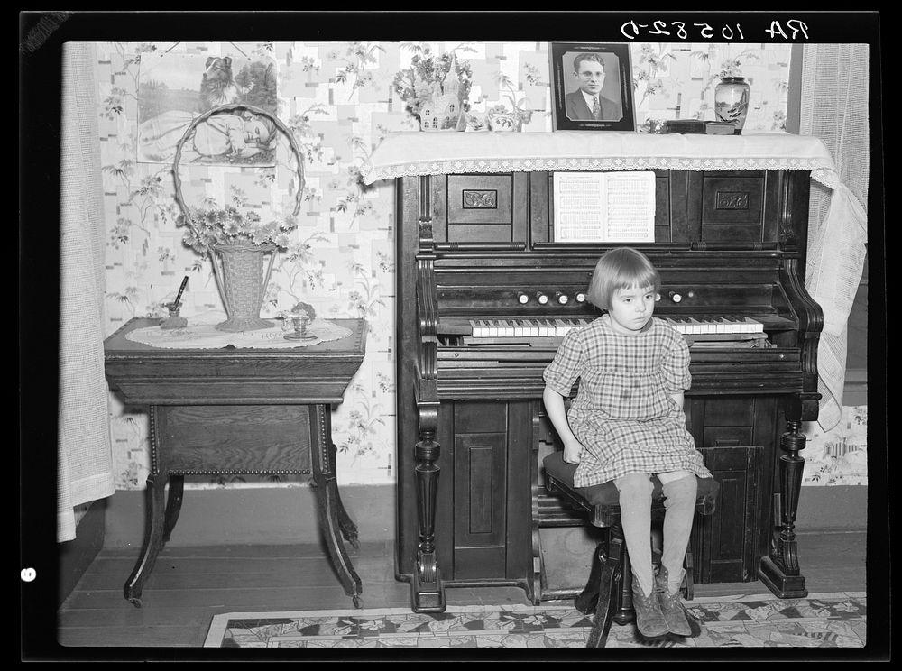 7:45 p.m. After dinner the family sits around in the living room. This is one of the daughters sitting on the stool for the…