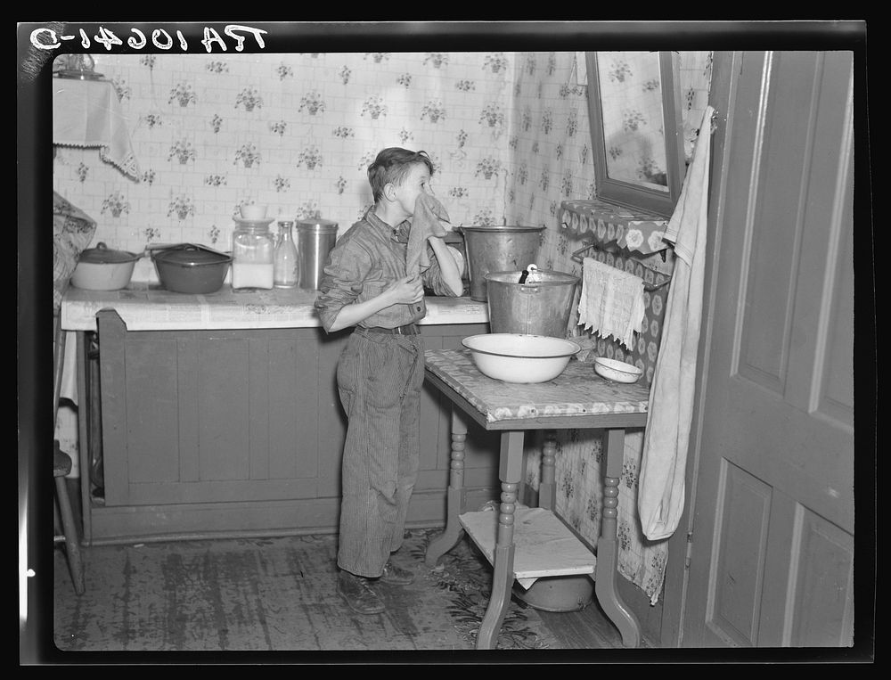 6:45 a.m. Son of Tip Estes washing his face after doing his early morning chores. Near Fowler, Indiana by Russell Lee