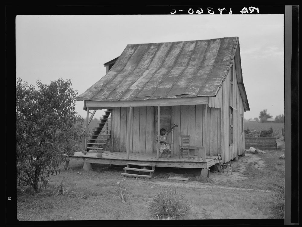 Cotton field hand sitting on her porch on Sunday afternoon. Near Blytheville, Arkansas. Sourced from the Library of Congress.
